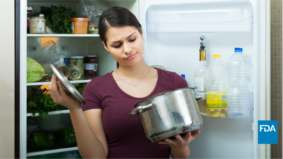 Women looks at pot of leftover food removed from her refrigerator