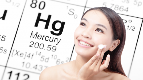 Asian woman applying skin cream with mercury element in the background.