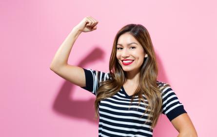Happy young woman with arm up