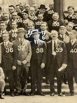 Group picture of men in suits, with a number appearing on each person (') s image. The man labeled 38 is highlighted.