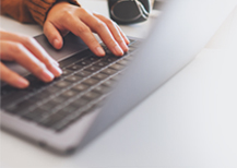 A person typing at a laptop