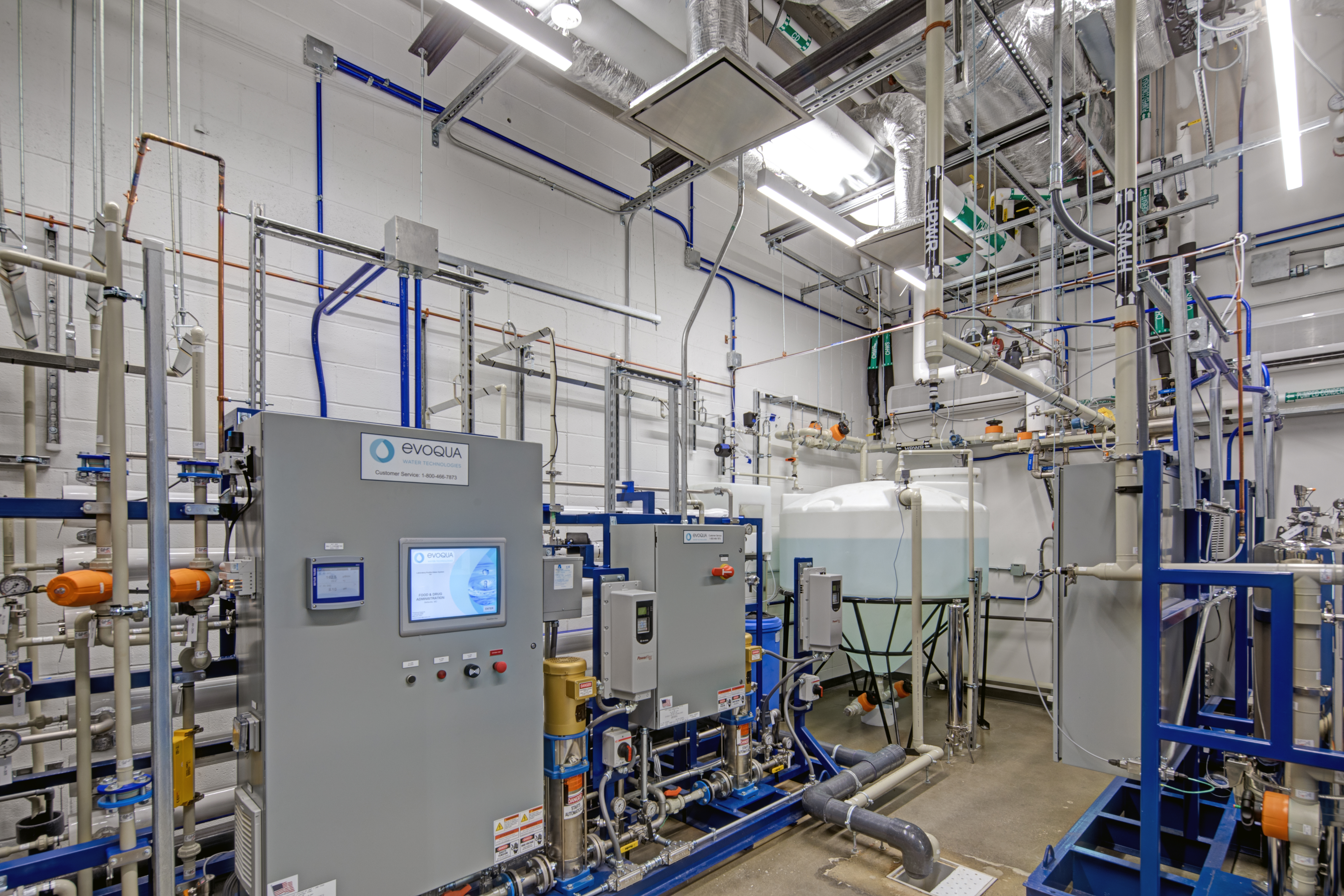 The image displays advanced manufacturing equipment at CDER’s Advanced Manufacturing Research Facility, featuring high-tech machinery and integrated systems used for innovative drug manufacturing processes. This setup highlights the state-of-the-art technology and infrastructure of the facility.