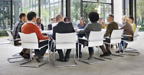 Diverse people talking around conference table