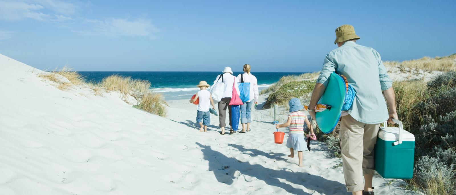 Family walking on sunny beach.