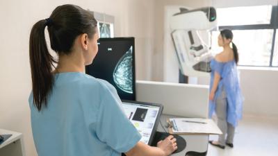 Picture of a doctor performing a mammogram on a patient.