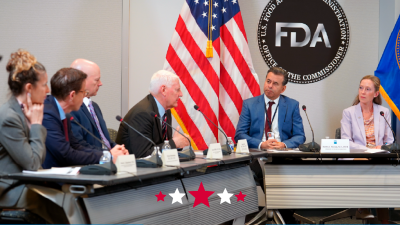 A group of people sitting at a table with microphones