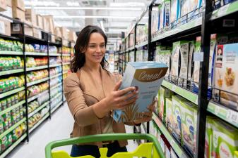 Woman is reading Cereal Box in the Supermarket