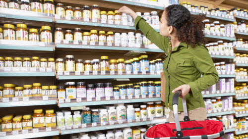 Photo of woman shopping in vitamin store for dietary supplements.