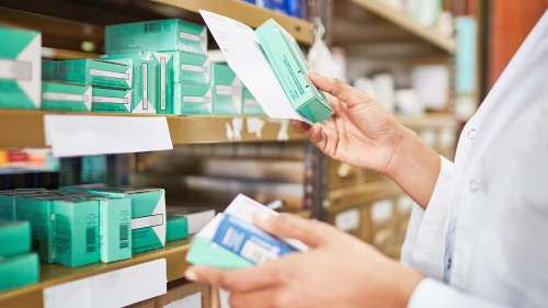 Pharmacist checking medicine boxes on a shelf, representing expiration date extension. In some cases, testing has shown that certain properly stored medical products can be used beyond their labeled expiration date if they retain their stability.  