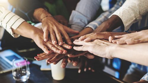 Multiracial group of people joining hands in stack