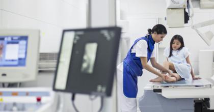 Photo of health care provider working stubborn young patient for an x-ray