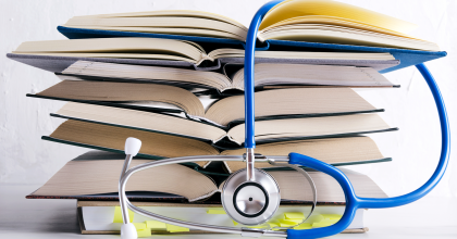 Stack of books with a stethoscope draped over them