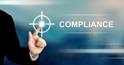 a finger pointing at the word compliance