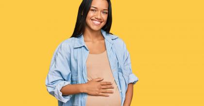 Pregnant young woman cradling her stomach