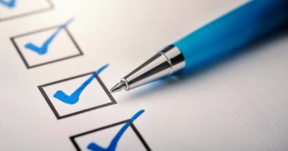 blue pen marking a checklist