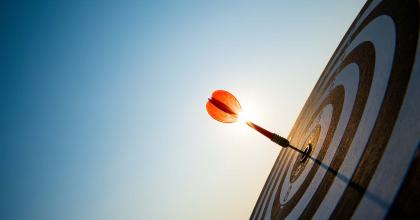 Close up of red dart on bullseye target