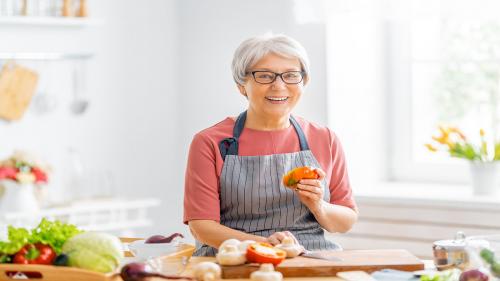 Happy woman prepping food in kitchen